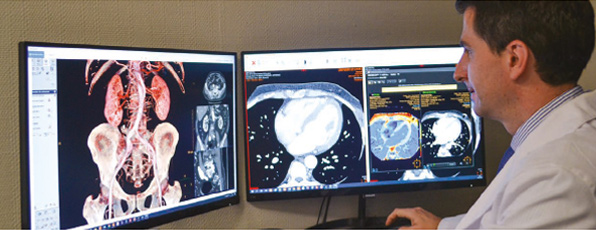 Profesional comprobando tomograf&iacute;as y resonancias magn&eacute;ticas en el monitor