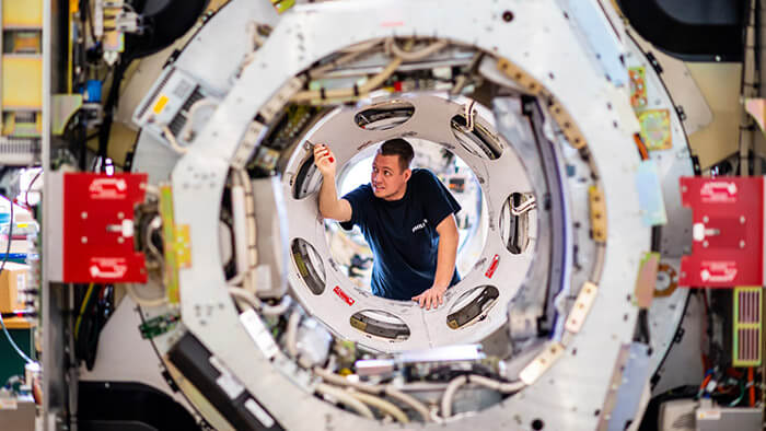 Hombre ajustando las piezas de la m&aacute;quina